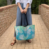 Woman holding "Palm Beach" large canvas tote bag, used as a reusable beach bag tote, everyday carryall, or cute tote bag for women. If you like Free People tote bags, then you’ll love this stylish weekender.