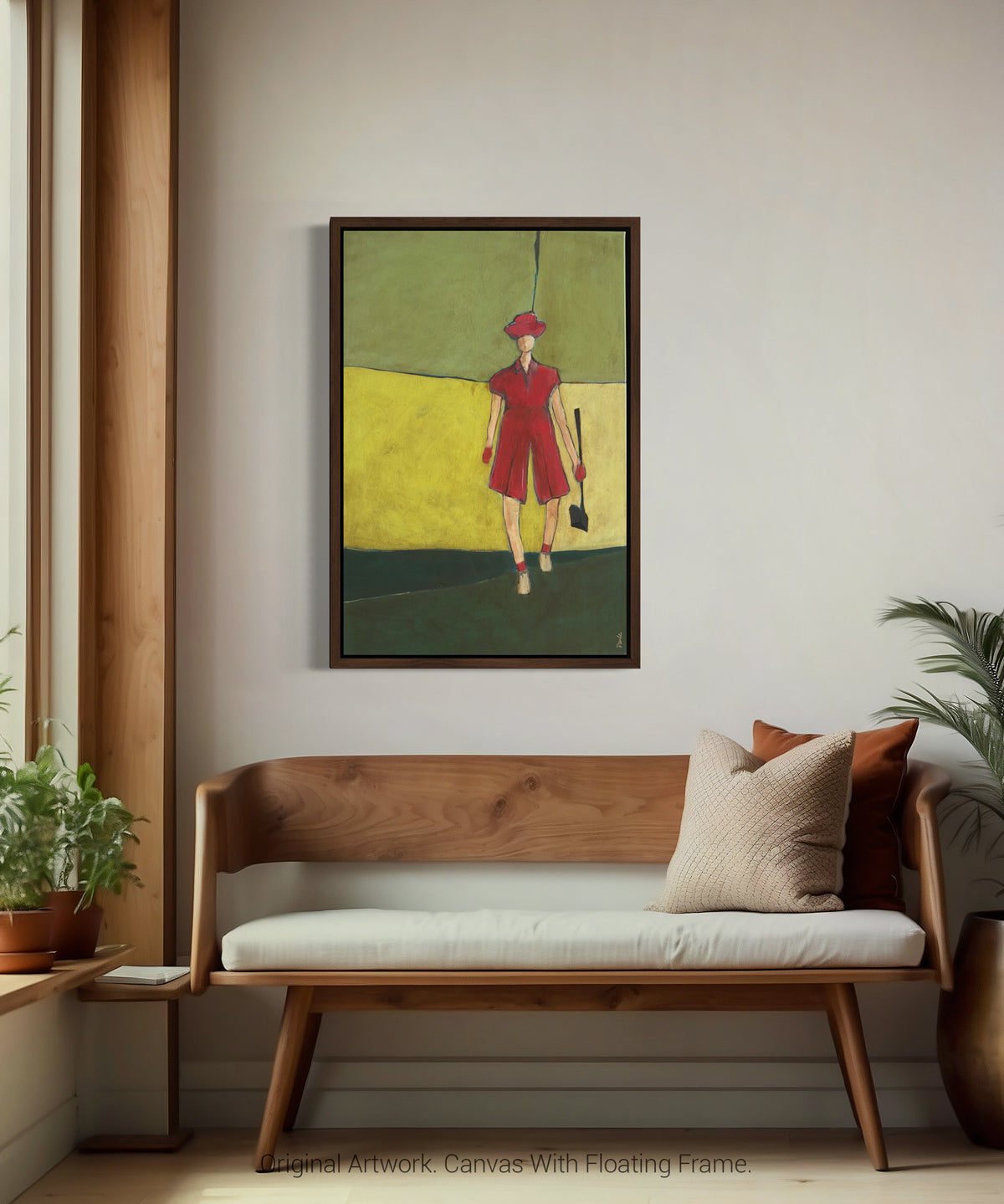Framed artwork of a woman in a female golfer in pink displayed in a floating dark wood frame, modern artwork for home decor on a wall above a wooden bench with cushions.