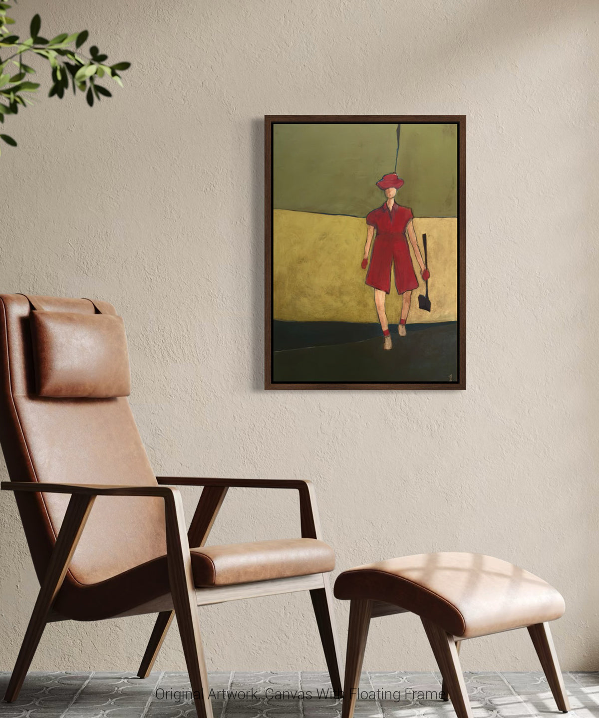 Framed wall art of a female golfer in pink displayed in a floating dark wood frame, modern artwork for home decor on a beige wall above a brown leather chair.