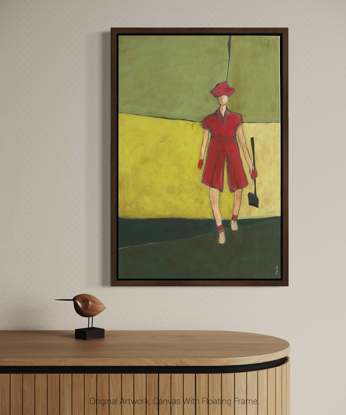 Framed wall art of a female golfer in pink displayed in a floating dark wood frame, modern artwork for home decor, displayed above a wooden cabinet.