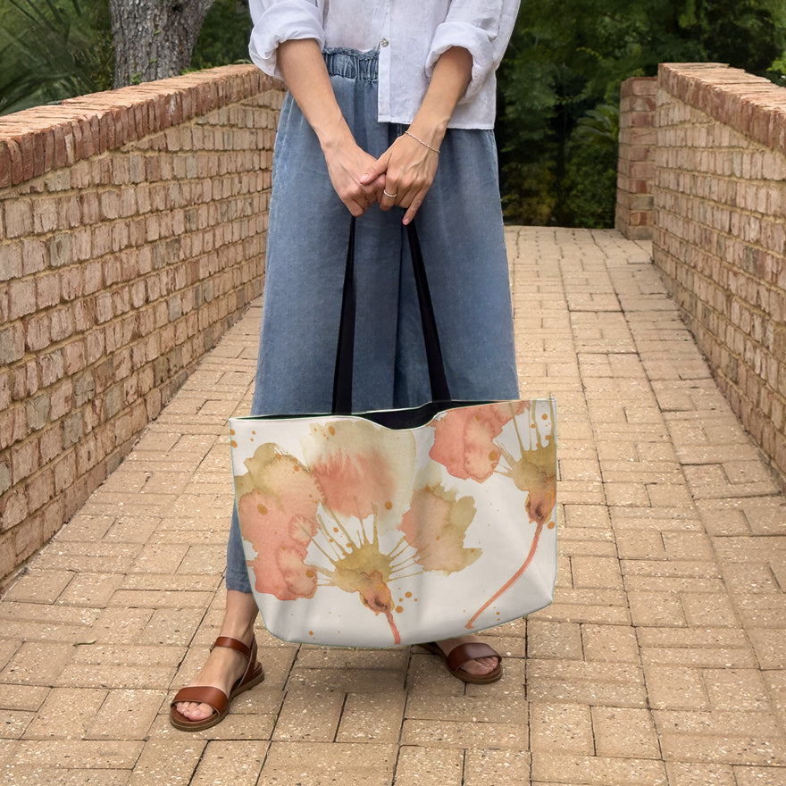 Woman holding a large canvas tote bag, used as a reusable beach bag tote, everyday carryall, or cute tote bag for women. If you like Free People tote bags, then you’ll love this stylish weekender.
