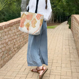 Woman walking outdoors holding a large canvas tote bag, used as a reusable beach bag tote, everyday carryall, or cute tote bag for women. If you like Free People tote bags, then you’ll love this stylish weekender.