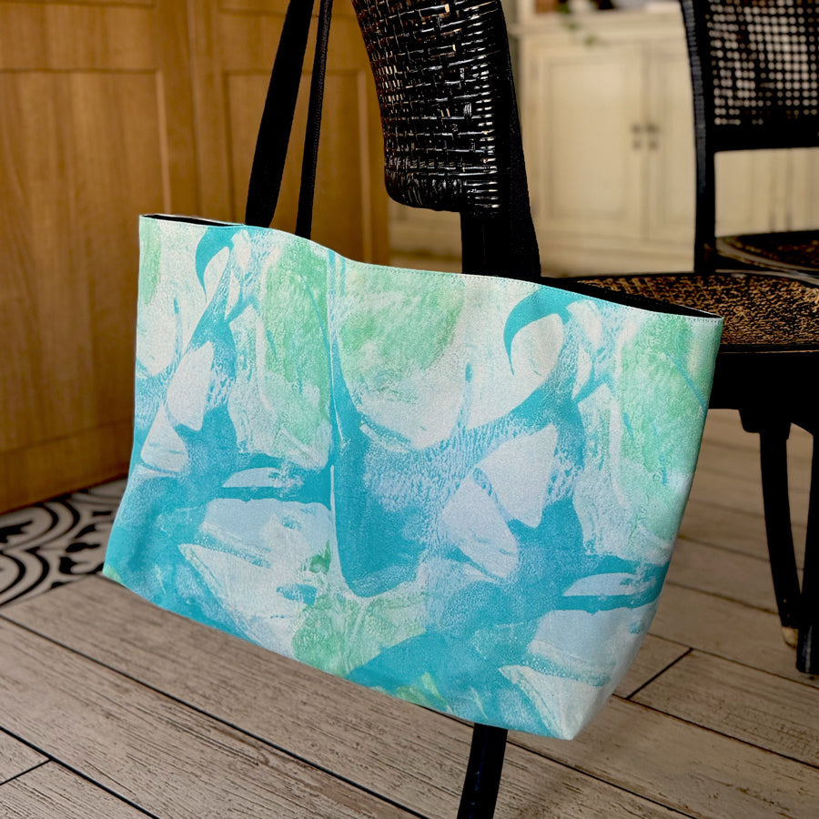 "Palm Beach" large canvas tote bag hanging on cafe chair, used as a reusable beach bag tote, everyday carryall, or cute tote bag for women. If you like Free People tote bags, then you’ll love this stylish weekender.