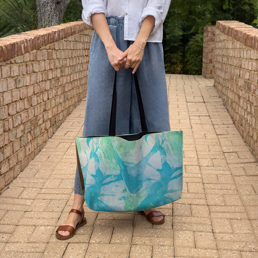 Woman holding "Palm Beach" large canvas tote bag, used as a reusable beach bag tote, everyday carryall, or cute tote bag for women. If you like Free People tote bags, then you’ll love this stylish weekender.